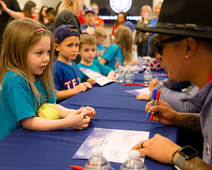 jesse chavez autographs a softball for a young fan